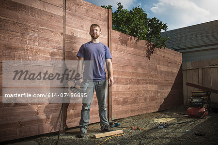 Portrait of joiner in backyard in front of new fence