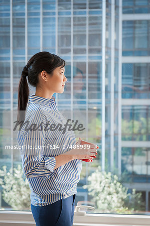Portrait of young businesswoman looking out of window
