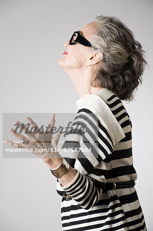 Portrait of senior woman, arms open, side view