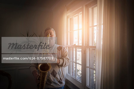 Mature man at home practicing saxophone