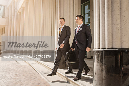 Two business lawyers with briefcase leaving courthouse