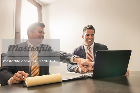 Two male business lawyers chatting in office