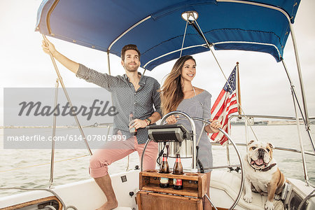 Mid adult couple on sailing boat with dog