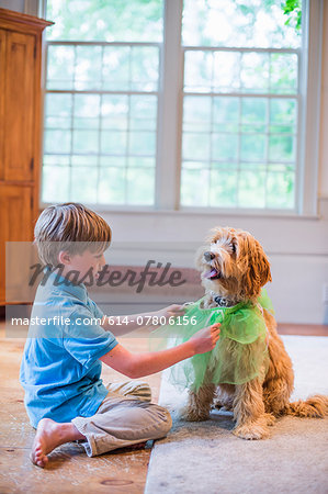Young boy playing dress up with pet dog