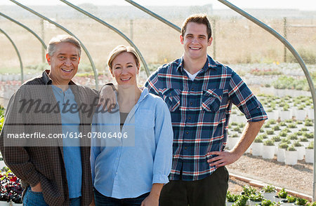 Portrait of three workers in plant nursery polytunnel