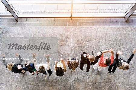 Overhead view of business team in a row jumping for joy