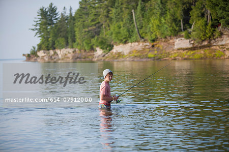 Wading teenage boy fishing in Lake Superior, Au Train Bay