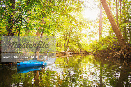 Young woman kayaking on forest river, Cary, North Carolina, USA