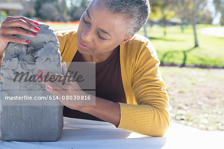 Mature woman making pottery, Hahn Park, Los Angeles, California, USA Mature woman making pottery, Hahn Park, Los Angeles, California, USA