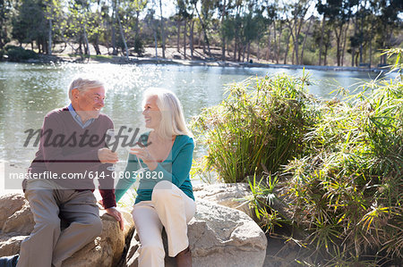 Husband and wife toasting by lake, Hahn Park, Los Angeles, California, USA