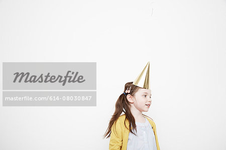 Girl wearing cone party hat