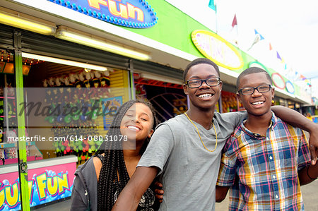 Portrait of teenage boys and sister at amusement park