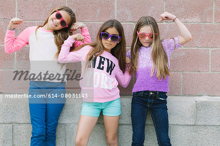 Three girls flexing muscles
