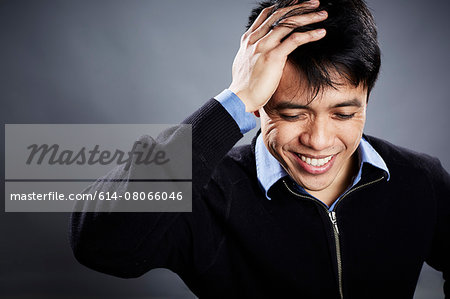 Portrait of mid adult man touching head