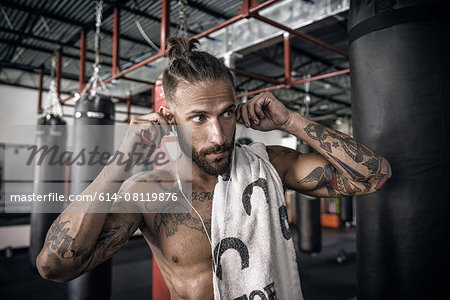 Male boxer putting in earphones at gym