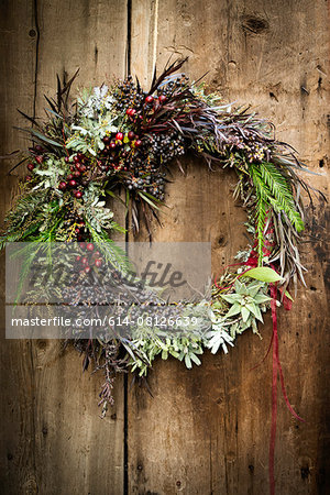 Christmas wreath with foliage and berries on wooden door