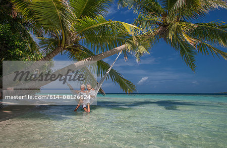 Senior couple relaxing in hammock, Maldives Senior couple relaxing in hammock, Maldives