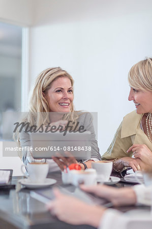 Business woman using digital tablet at business lunch