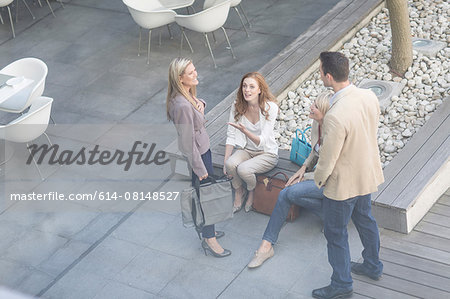 High angle view of businessman and women chatting on hotel terrace
