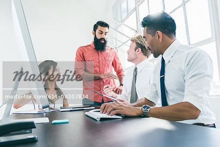 Business people in brainstorming meeting by office window