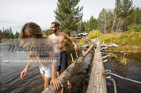 Young couple crossing river, Lake Tahoe, Nevada, USA