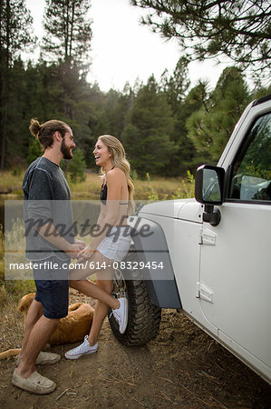 Young couple holding hands next to jeep on riverside, Lake Tahoe, Nevada, USA