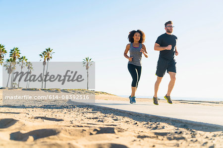 Couple running on pathway at beach, low angle view