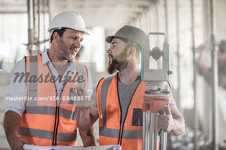 Surveyor explaining to site foreman on construction site