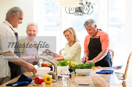 Group of seniors preparing meal in kitchen