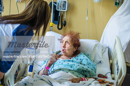 Patient on hospital bed talking to visitor