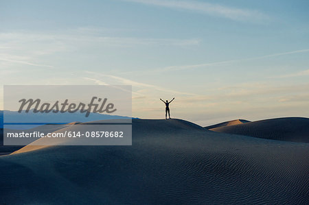 Person stretching arms at sunset, Death Valley, California, USA