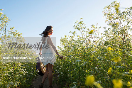 Woman with guitar in field of wildflowers