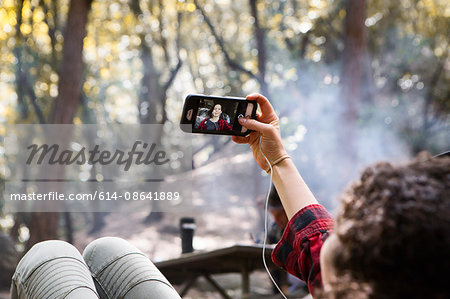 Over shoulder view of young female hiker taking smartphone selfie in forest, Arcadia, California, USA
