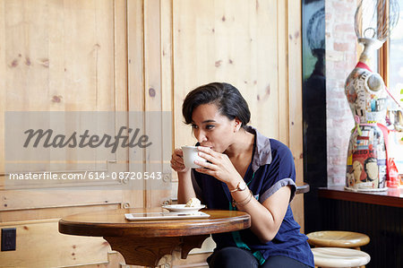 Young woman sitting in cafe, drinking coffee