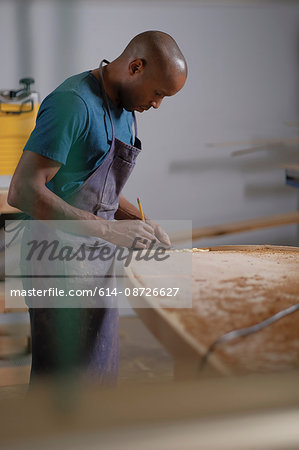 Craftsman making paddleboard in workshop