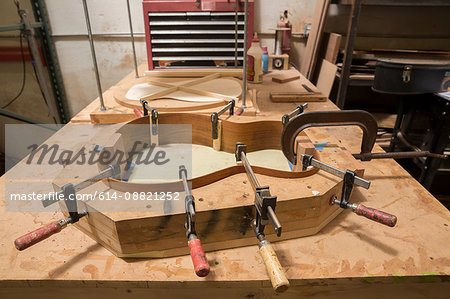 Guitar clamped in mould in workshop