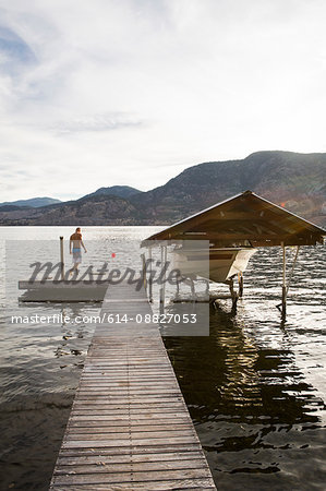 Man with boat moored on pier, Penticton, Canada