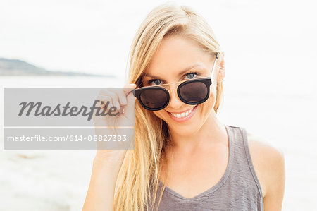 Portrait of woman wearing sunglasses looking at camera smiling