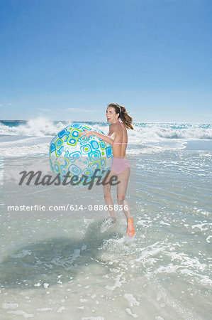 A girl running with a beach ball
