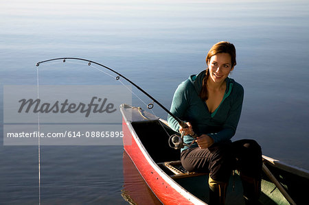 Woman fishing from canoe - Stock Photo - Masterfile - Premium Royalty-Free,  Code: 614-08865895