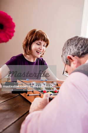 Eldery couple playing table soccer game