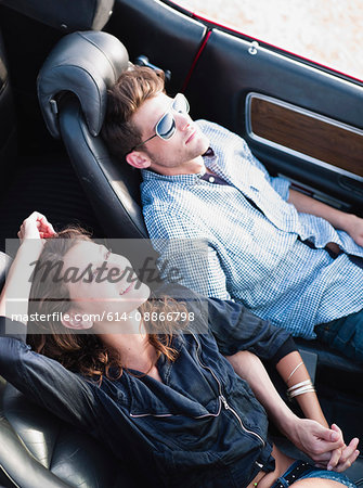 couple lying in open-topped car