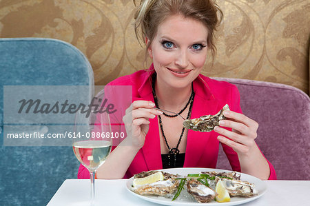 Woman having oysters in restaurant