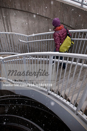 Woman climbing staircase in snow