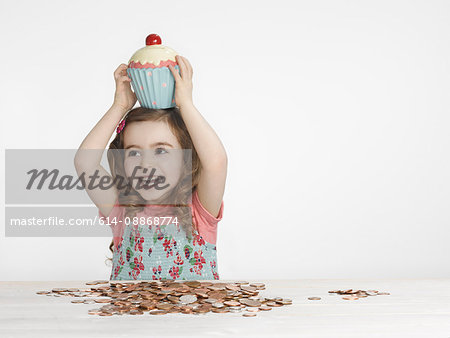 Girl holding cupcake jar on head