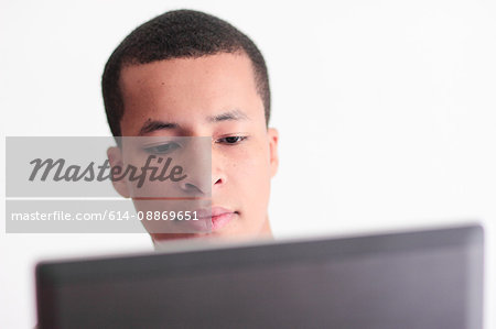 Teenage boy using laptop indoors