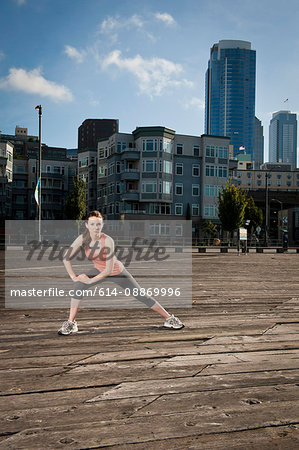 Woman stretching on city street Woman stretching on city street
