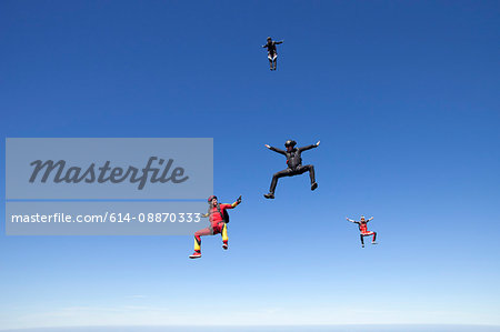 People skydiving over clouds