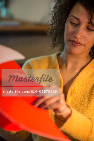 Woman folding red cardboard