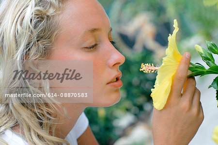 Close up of woman smelling flower